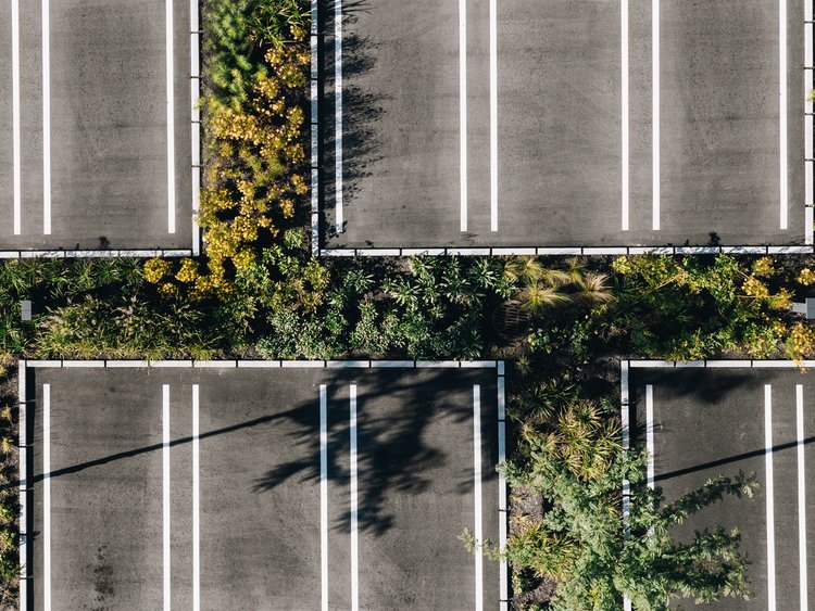 Ansicht eines Parkplatzes von oben – mit begrünten Flächen und klar getrennten Parkflächen.
